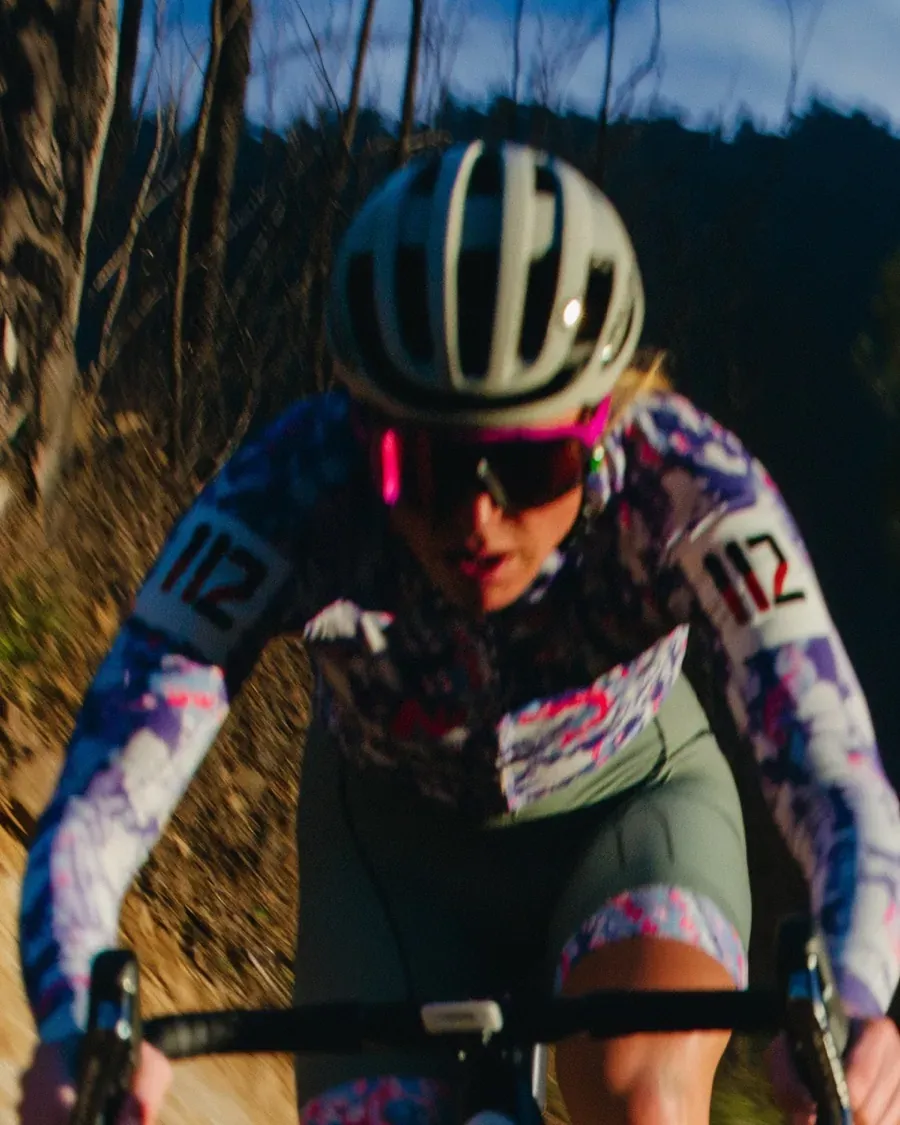 A cyclist riding relaxed on an open gravel road
