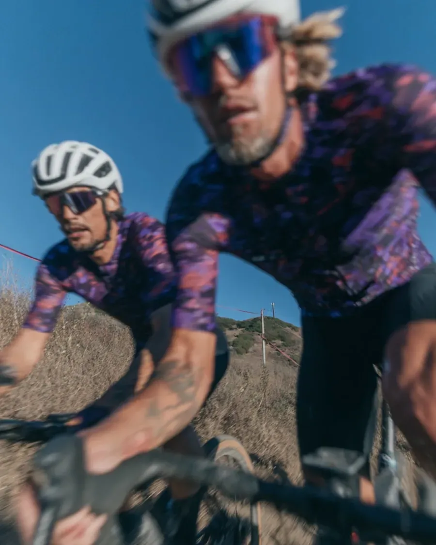 Two riders celebrating together as they cross a finish line