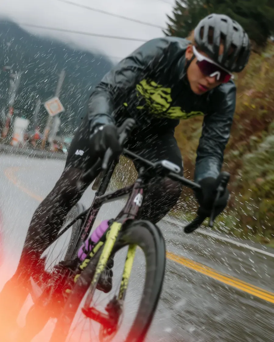 A road cyclist pushing on through rain and spray
