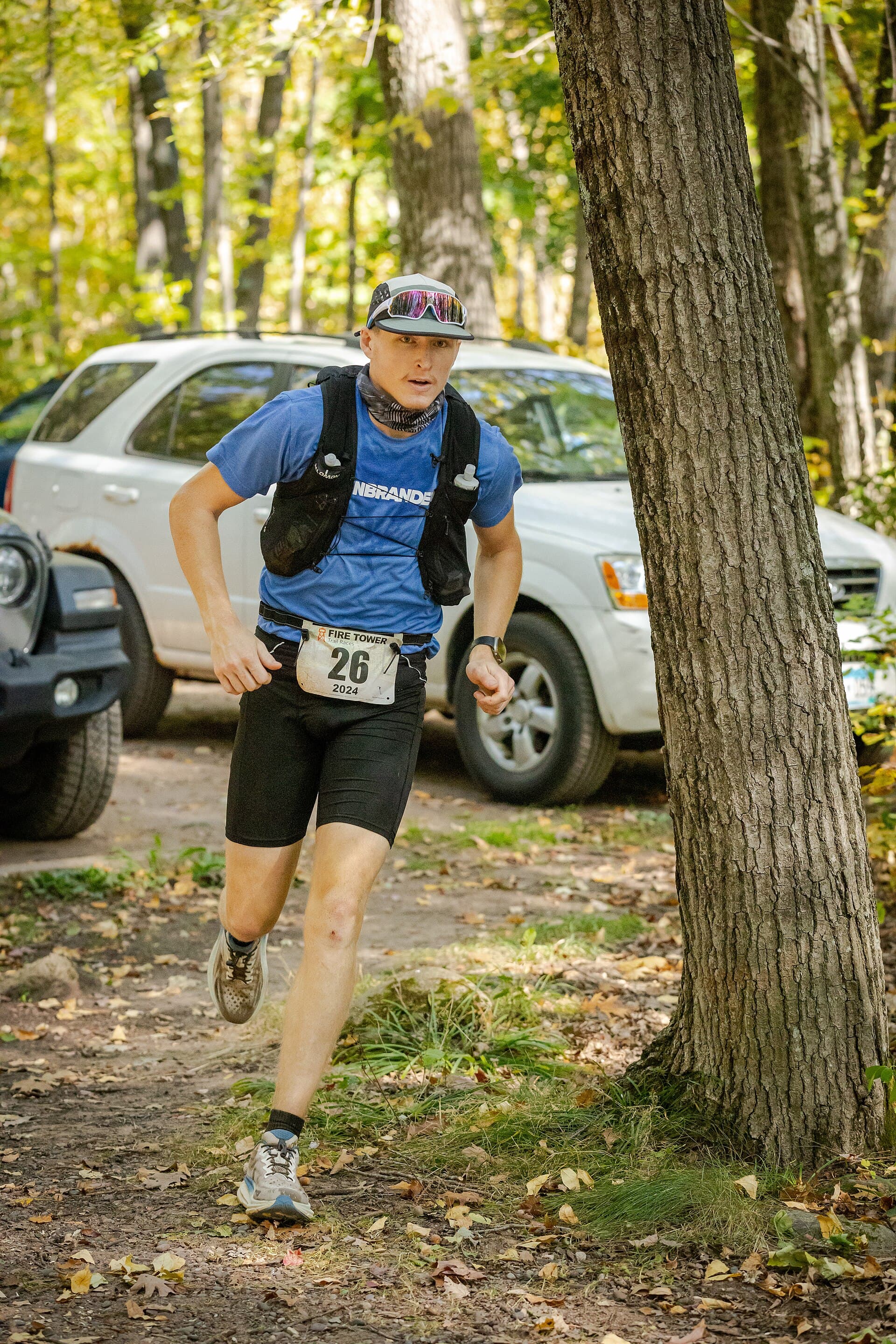 A trail runner in autumn colours below a fire tower